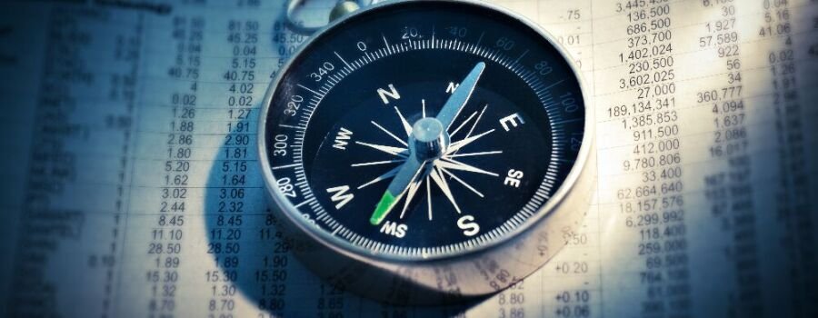 Ein Kompass auf einer Zeitung mit Börsenkursen (Symbolbild).