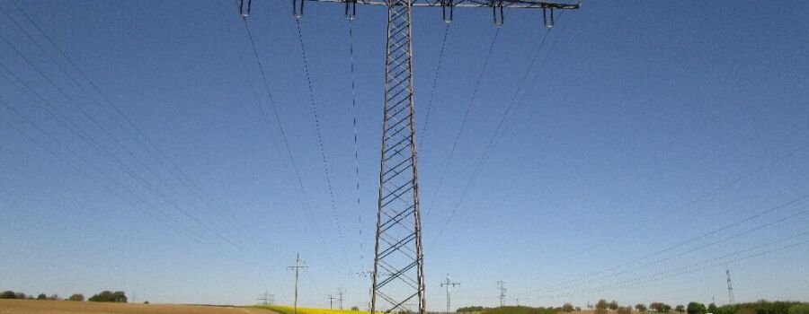 Stromleitung über einem Rapsfeld (Symbolbild).