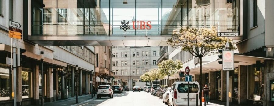 UBS-Logo tagsüber auf gläserner Brückenwand