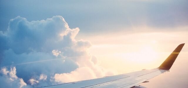 Die Tragfläche eines Flugzeugs bei Sonnenuntergang (Symbolbild).
