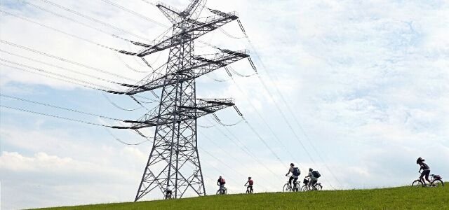 Ein Strommast auf einem Deich (Symbolbild).