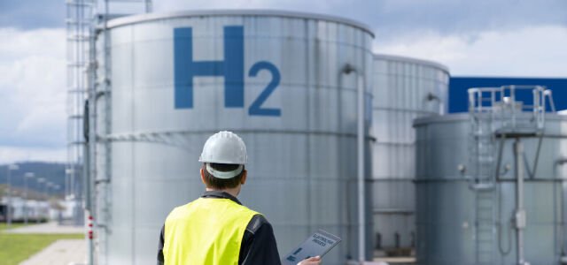 Ingenieur mit einem Hintergrund der Wasserstofffabrik (Symbolbild)